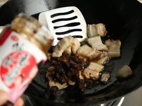 炒锅放油，五花肉和葱姜同炒，炒至五花肉变的透亮油润，加入香菇酱。