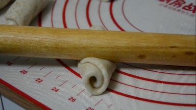 用擀面杖顺着长度方向，再次擀成长舌状