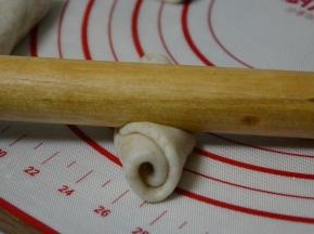 用擀面杖顺着长度方向，再次擀成长舌状