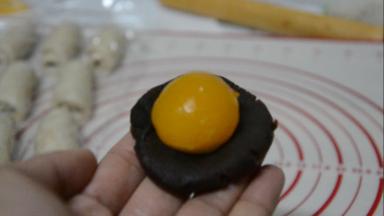 蛋黄+红豆沙＝40g，蛋黄放在红豆沙中间，虎口上推，收紧