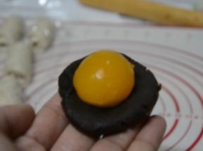 蛋黄+红豆沙＝40g，蛋黄放在红豆沙中间，虎口上推，收紧