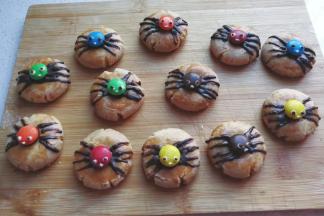 最后再把少许白巧克力放在小勺子中隔热水融化，用牙签粗头沾上白巧克力点上蜘蛛的眼睛和嘴巴，再沾点黑巧克力点成黑色眼珠，呆萌可爱的小蜘蛛就做好啦！