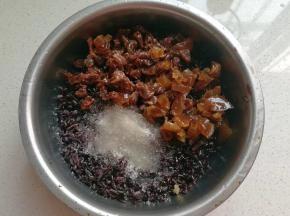 泡好的黑米沥掉水份倒入大碗中，加入适量白糖（或红糖）、蜜饯、猪油（或食用油）拌均匀；