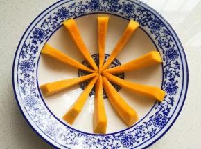 窝形深盘或碗中先刷上一层食用油，如图再摆上南瓜条，间距要适中；