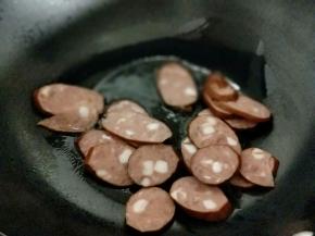 起油锅，加入切好的香肠片煸炒。