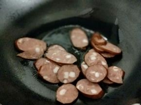 起油锅，加入切好的香肠片煸炒。