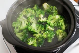 3、水里放一小勺盐、一勺食用油煮开后加入西蓝花煮熟捞出备用