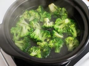 3、水里放一小勺盐、一勺食用油煮开后加入西蓝花煮熟捞出备用