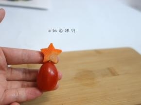 将一片胡萝卜压出五角星用牙签插在番茄上放在西蓝花顶部装饰