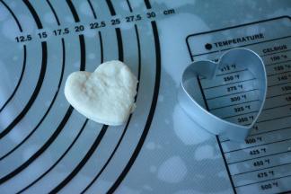 白色面团擀成薄片压出心形。重复压出多个心形。