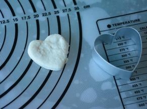 白色面团擀成薄片压出心形。重复压出多个心形。