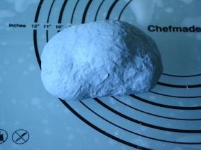 蓝色面皮将白色面团包裹严实:，边缘收口压紧。