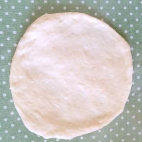 取出醒好的一个面团，排气、揉圆，用擀面杖将其擀平，直径约为16厘米上下。

面团擀好是会回缩的，千万不要着急，一边继续醒一边擀。