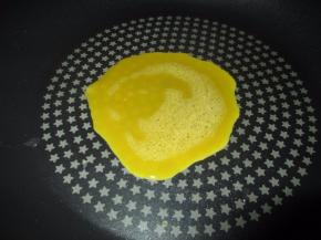 然后准备好平底锅，中间抹一点油，加热，倒入一大勺蛋液