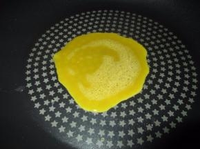 然后准备好平底锅，中间抹一点油，加热，倒入一大勺蛋液