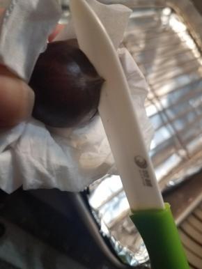 然后用小刀在栗子尖的方向划一个十字口，防止栗子烤制过程中爆锅。