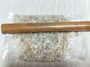 将熟花生放入食品袋中，用擀面杖来回高压。将其擀碎。