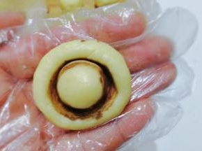 然后取一份小面团，左手拿面团，右手把碑酒瓶轻轻按压上去，一个可爱的小蘑菇就出来啦；（每做一个，碑酒瓶都要沾一次可可粉）