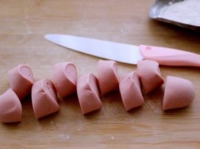 揉光滑的面团搓成长条、用刀切成大小一致的剂子