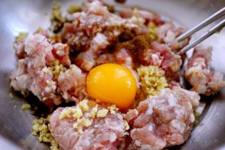 猪肉馅里加入一个鸡蛋、花椒粉、料酒、老抽、生抽和味精和姜末调味、然后顺时针搅拌上劲