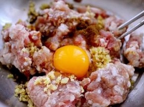 猪肉馅里加入一个鸡蛋、花椒粉、料酒、老抽、生抽和味精和姜末调味、然后顺时针搅拌上劲