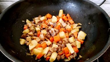 放入土豆和胡萝卜翻炒几下。