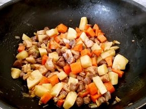 放入土豆和胡萝卜翻炒几下。