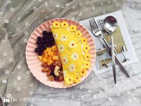 然后用番茄酱在小花上点出花芯即可。我在盘子的另一边放了蓝莓、芒果和每日坚果。这个可以按个人口味来摆。