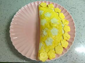 把蛋皮盖上炒饭，边缘压一压，再把之前压出的小花摆在边上。