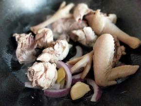 起油锅，加入葱姜蒜炒香，再加入焯过水的鸡块煸炒。