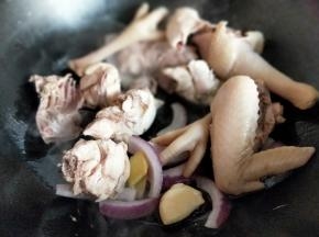 起油锅，加入葱姜蒜炒香，再加入焯过水的鸡块煸炒。
