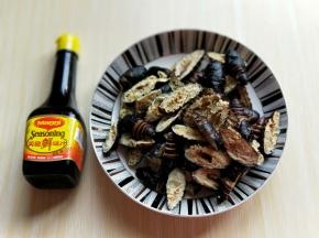 首先将蚕蛹处理好，冷水洗干净，再焯水，捞出淋干水份，再将蚕蛹从中间剪开(一剪二)