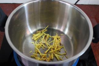 把切好的生姜丝，放入锅中；