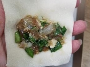 取出一块面皮，放上少许馅料，保证一个大虾仁哟。