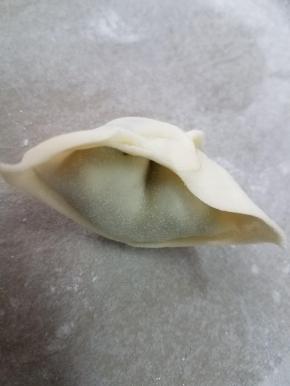 两边向内折，捏紧，一个馄饨就完成了。