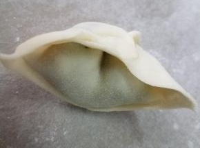 两边向内折，捏紧，一个馄饨就完成了。
