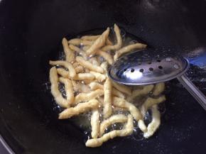 锅中放入玉米油烧至6分熟，将胚条分次投入油锅里炸成金黄色（如果觉得油温不好把握，可以先扔一条胚条到油锅里试试，如果胚条很快浮起来并膨胀，就表示油温可以了）