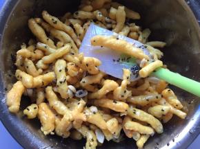 将糖浆倒入炸好的胚条中，加入花生和芝麻（花生提前放烤箱烤5分钟，去皮）趁热快速拌匀，尽量使每一根胚条蘸上糖浆