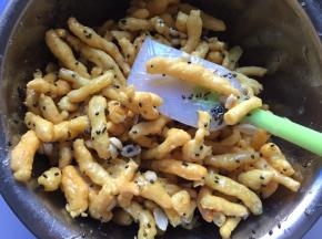将糖浆倒入炸好的胚条中，加入花生和芝麻（花生提前放烤箱烤5分钟，去皮）趁热快速拌匀，尽量使每一根胚条蘸上糖浆