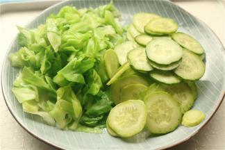 汤锅加水烧开，下入甘蓝绰烫30秒，捞出待用，黄瓜也切片。