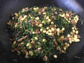 放入雪菜粒和泡发好的黄豆，翻炒至熟后加入1小勺花椒油，盛出备用。