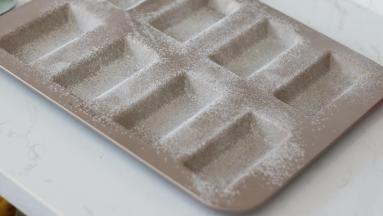 首先，取材料外的少量黄油软化，用刷子刷在模具内壁，撒上低粉。然后倒扣磕掉多余的低粉。放入冰箱冷藏备用