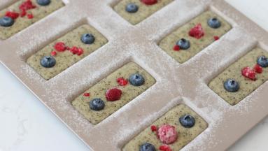 装入裱花袋之后，挤入处理好的模具。摆放上蓝莓，覆盆子。然后轻磕震模几次。