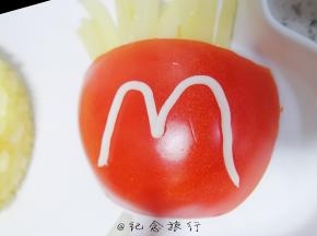 将番茄放在盘子里 放上土豆条，用沙拉酱写出一个m