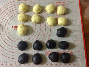 然后把面团分别排气，分别分出8个小面团，每个30克，黑白两个颜色一共16个。剩余的面团留做耳朵用。