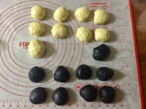 然后把面团分别排气，分别分出8个小面团，每个30克，黑白两个颜色一共16个。剩余的面团留做耳朵用。