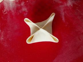 四宝是把饺子皮平均分成四份，在中间捏紧，如图，