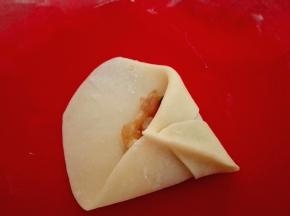 把尖端向圆弧边翻过去，与直边捏紧，