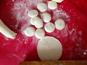 用手掐成大小一致的面剂子，撒上干面粉，防粘，先把面剂子按成圆饼，再用擀面杖擀成圆盘，