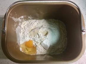 把牛奶、鸡蛋放入面包桶，盐和糖对角线放入，铺上面粉，在面粉上掏一个洞，把酵母倒进去。黄油先不放。
